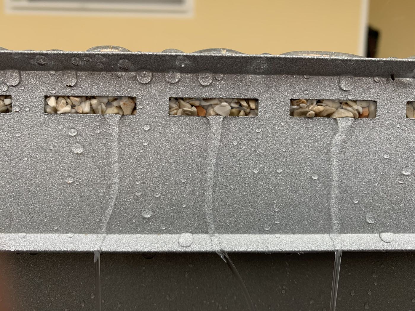 Entwässerungsschlitze im Drainrandprofil mit ablaufendem Wasser