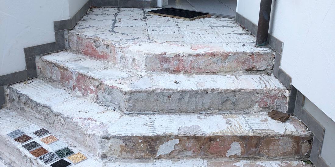 Eingangsstufen vor der Sanierung mit abgeplatztem Beton