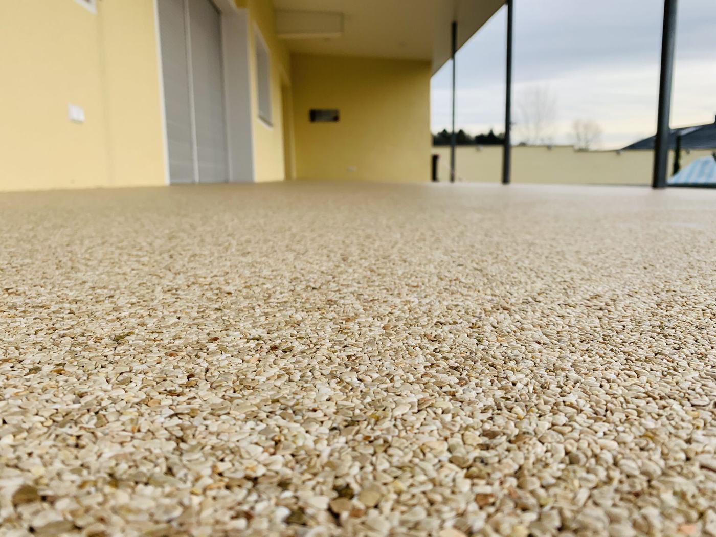 Nahaufnahme der sandfarbenen, fugenlosen Steinteppich-Oberfläche