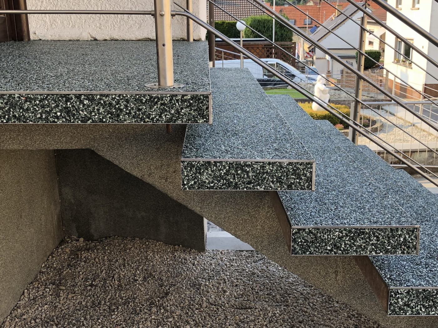 Außentreppe mit grauem Steinteppich und heller Trittkante