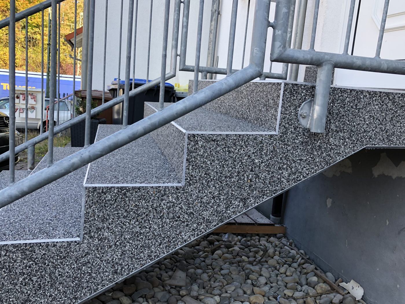 Treppe mit Steinteppich und Edelstahlgeländer